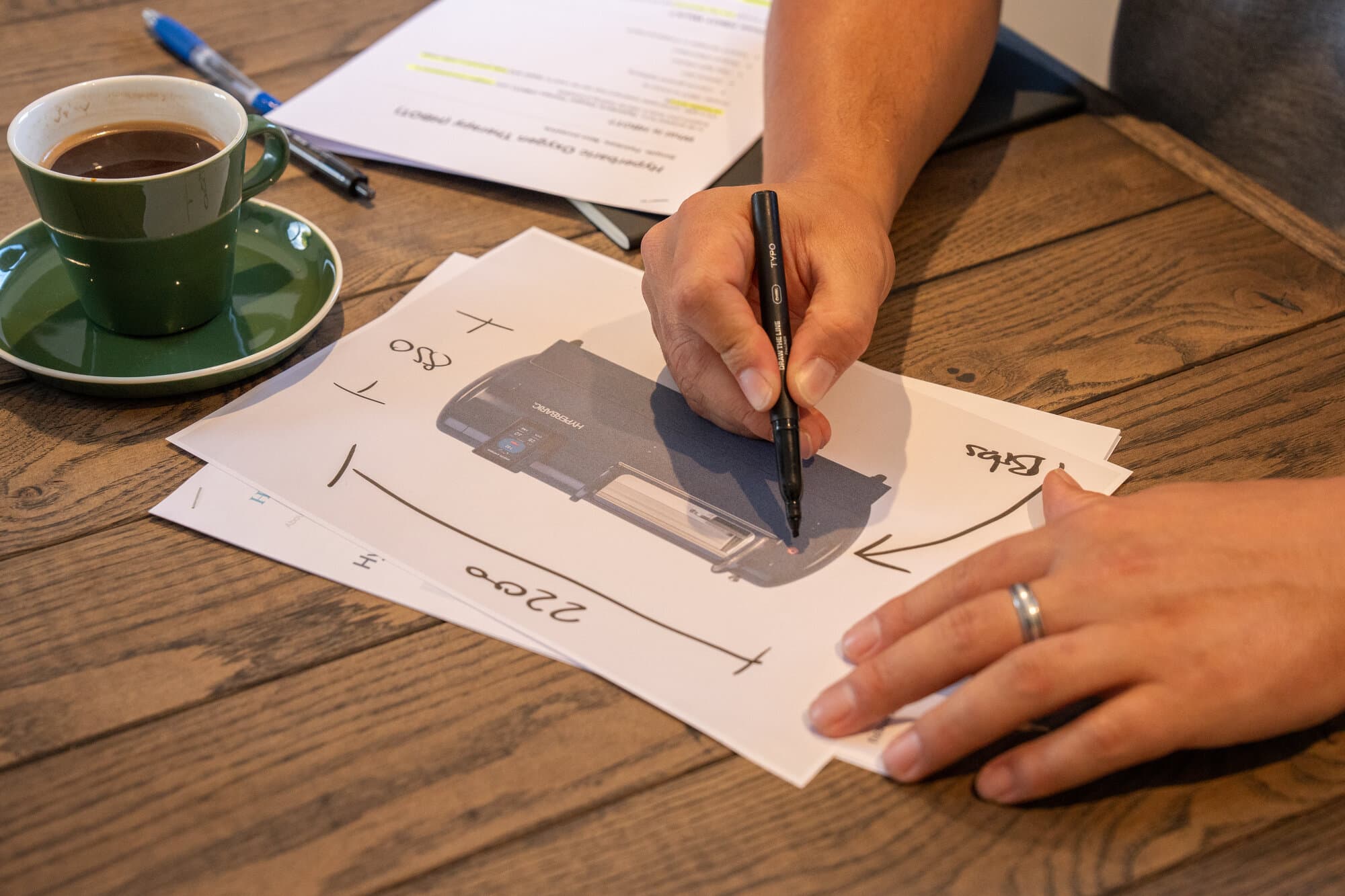 Hands sketching hyperbaric chamber dimensions during planning Hands sketching hyperbaric chamber dimensions during planning