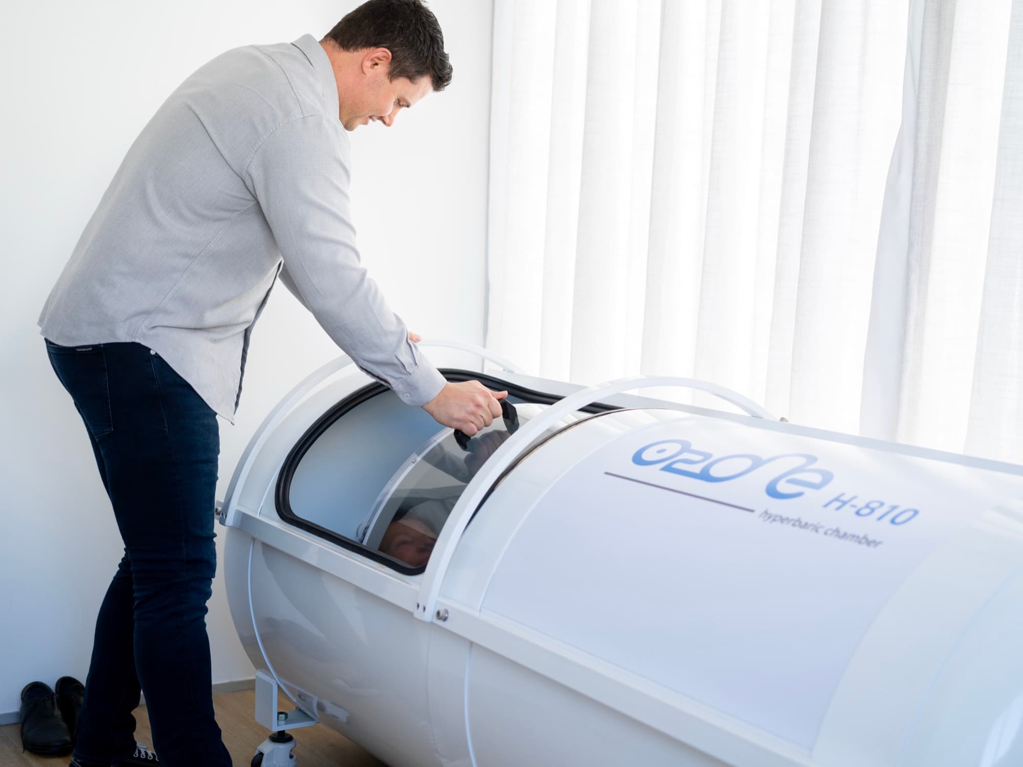 Callum closing the hyperbaric chamber door for a customer during a session