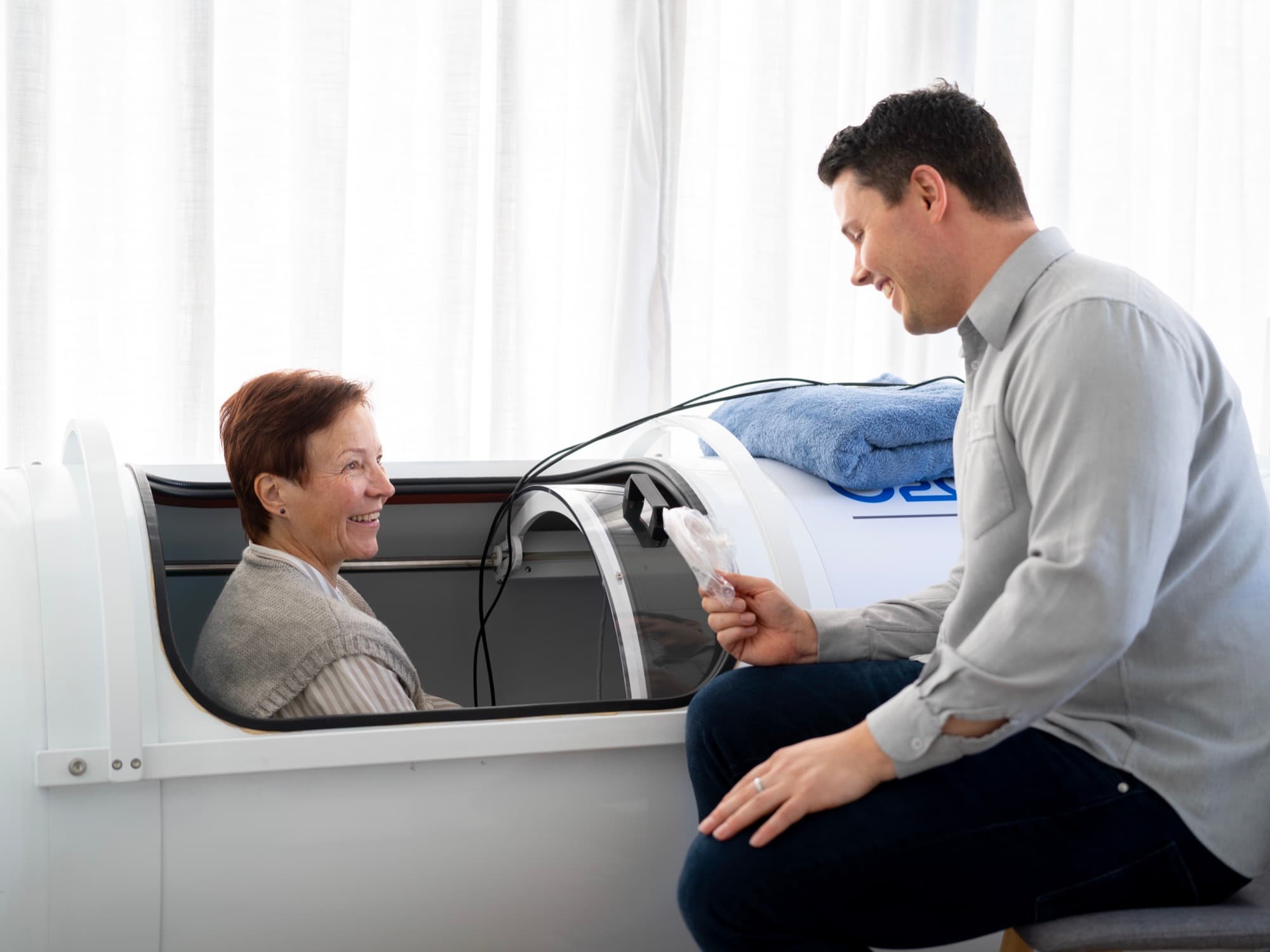 Customer in the hyperbaric chamber being guided through a session by Callum