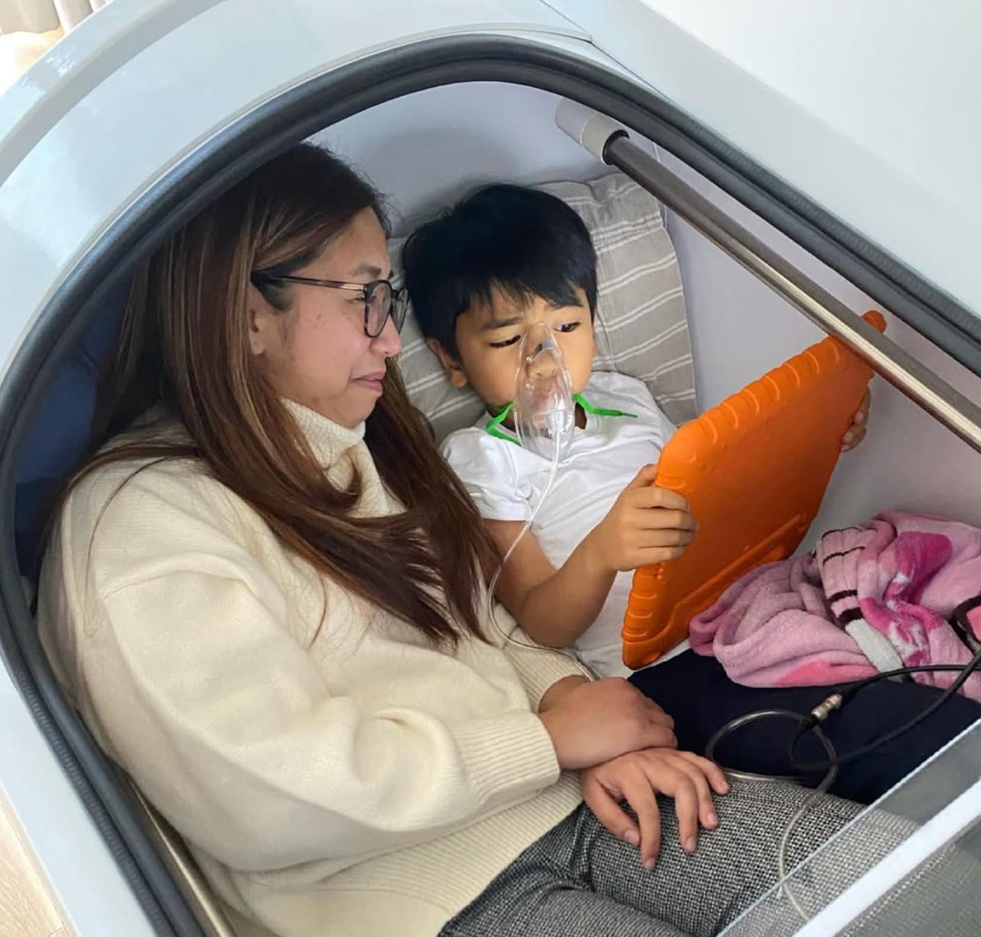 Mother and son relaxing together inside a hyperbaric chamber